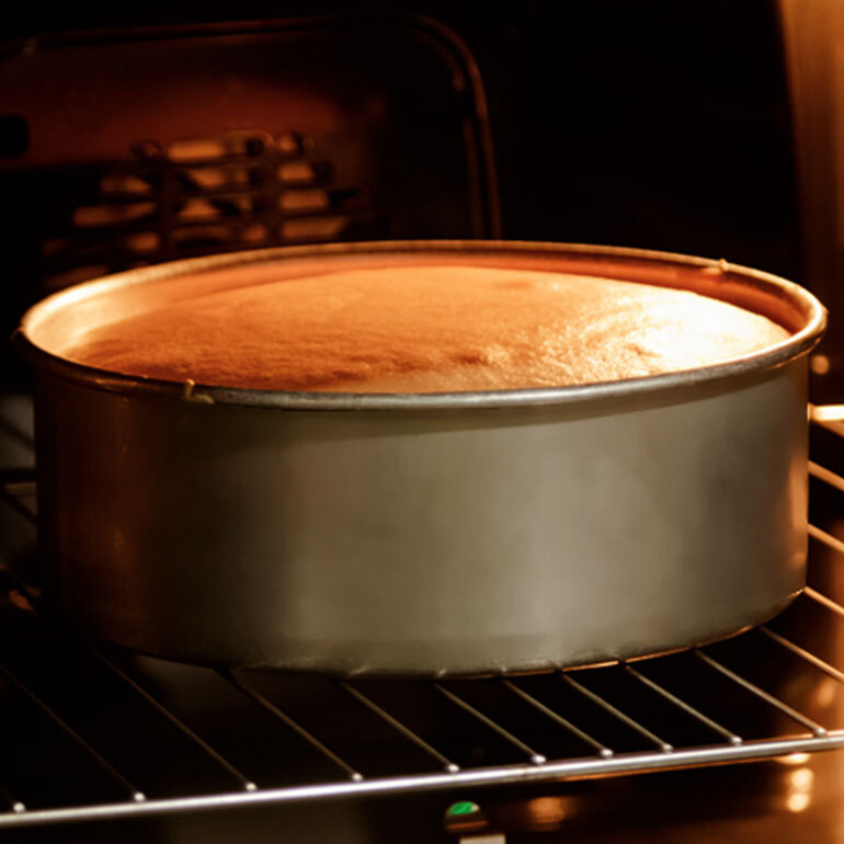 A tall round baking pan in the over