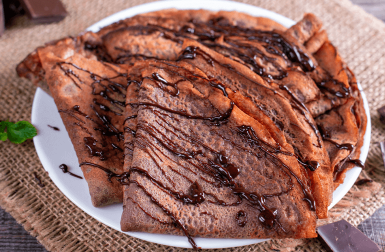 A plate of Chocolate Crepes topped with melted chocolate